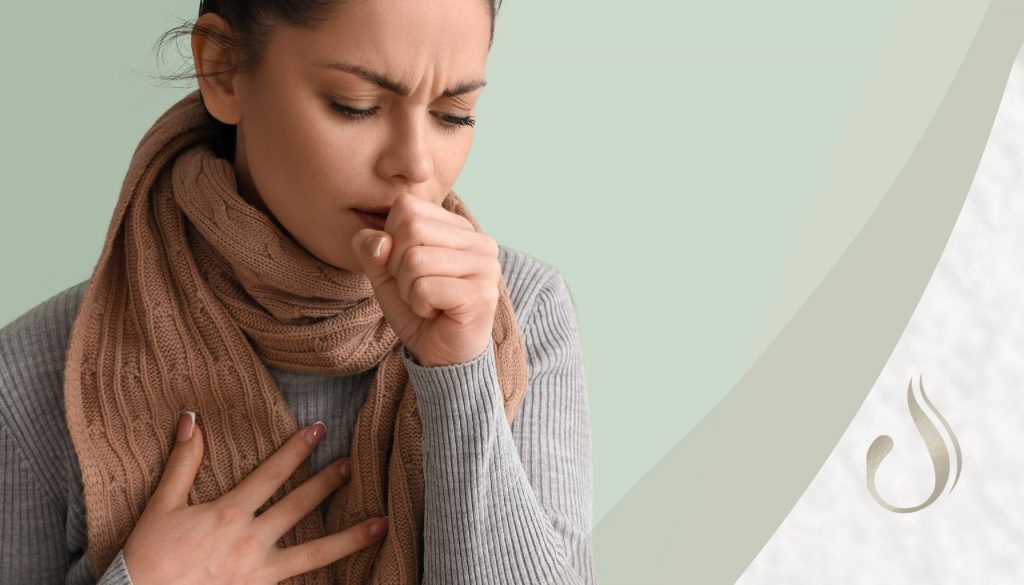 Frau mit Husten hält sich die Hand an die Brust zum Thema Rippenfellentzündung verstehen