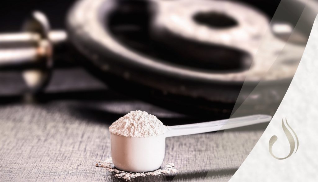 Nahaufnahme Löffel Kreatin mit Gewichten im Hintergrund